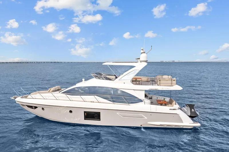 Slide: The Image of 2019 Azimut 55 yacht cruising on open water under a clear blue sky. - 3