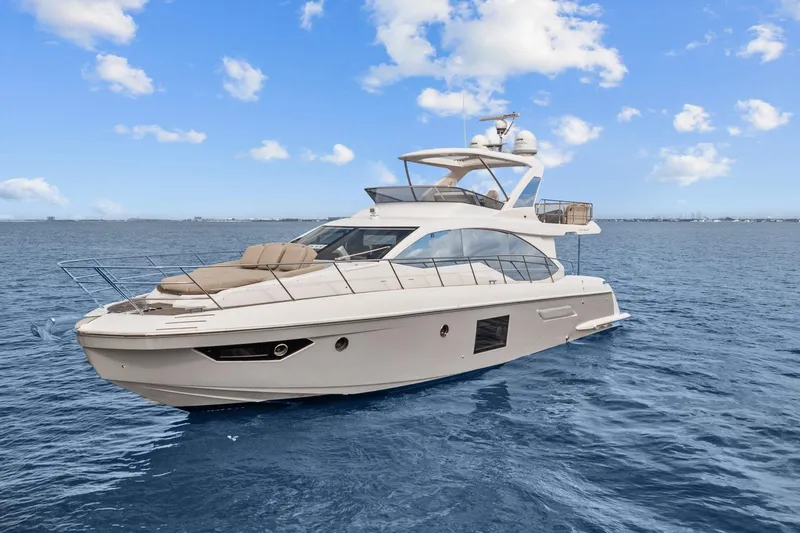 Slide: The Image of Luxury 2019 Azimut 55 yacht cruising on open sea under clear blue sky. - 4