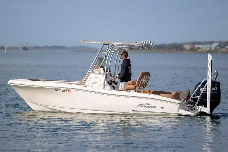 The Image of 2022 Pioneer 202 Islander boat cruising on calm waters with a Suzuki outboard motor. - 0