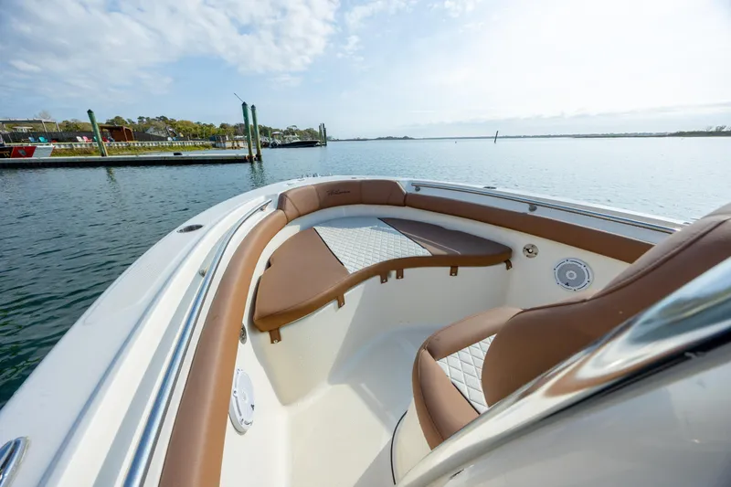 Slide: The Image of 2022 Pioneer 202 Islander boat interior with brown seating, docked by calm waters. - 11