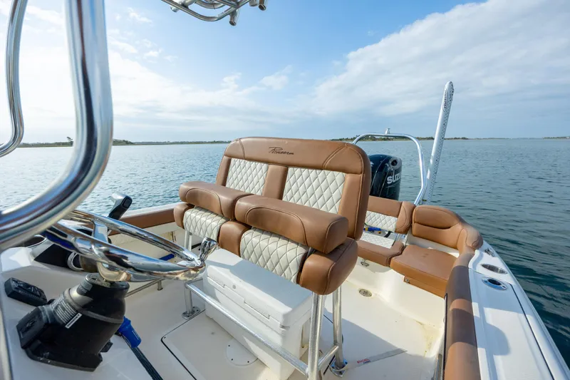 Slide: The Image of 2022 Pioneer 202 Islander boat interior with leather seating on calm water. - 14