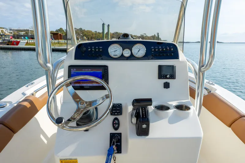 Slide: The Image of 2022 Pioneer 202 Islander boat dashboard with steering wheel and navigation instruments. - 15