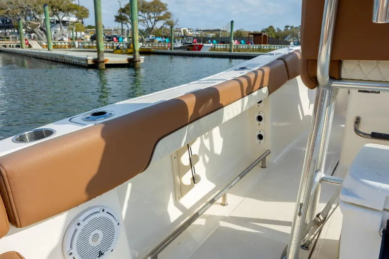 Slide: The Image of 2022 Pioneer 202 Islander boat interior with brown seating, docked at marina. - 17