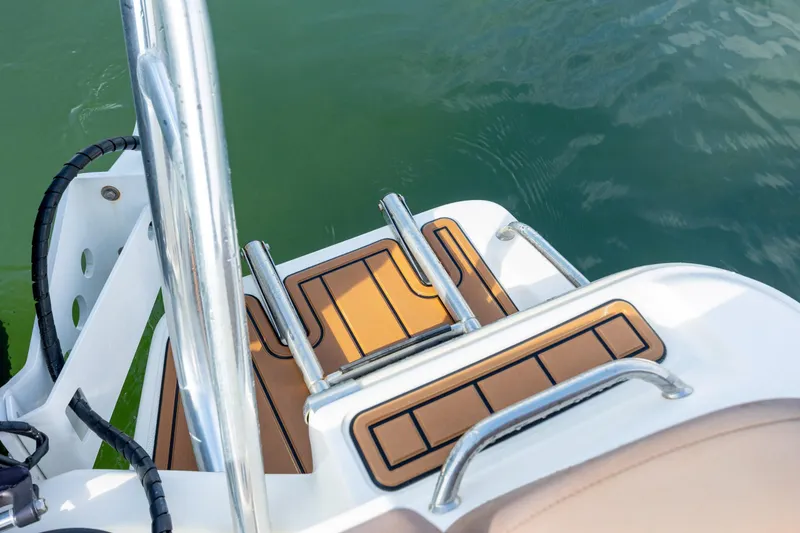 Slide: The Image of 2022 Pioneer 202 Islander boat swim platform with ladder and teak-style decking. - 22