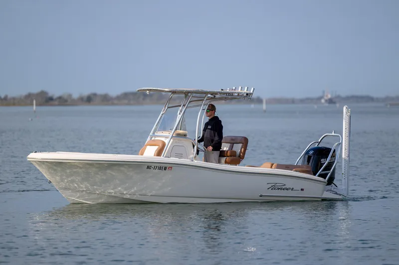 Slide: The Image of 2022 Pioneer 202 Islander boat on calm water with a person at the helm. - 9
