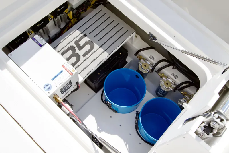 Slide: The Image of View of a Regulator 35 boat's engine compartment with two blue buckets and technical components. - 33