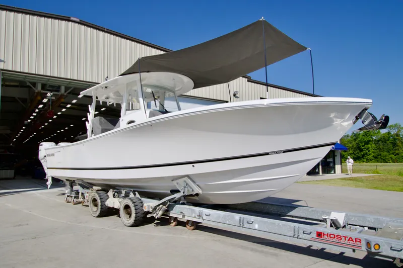 The Image of A white Regulator 35 boat on a trailer outside a building. - 0