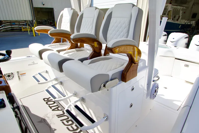 Slide: The Image of Three luxurious, cushioned seats with wooden armrests on a boat, surrounded by white interior. - 25