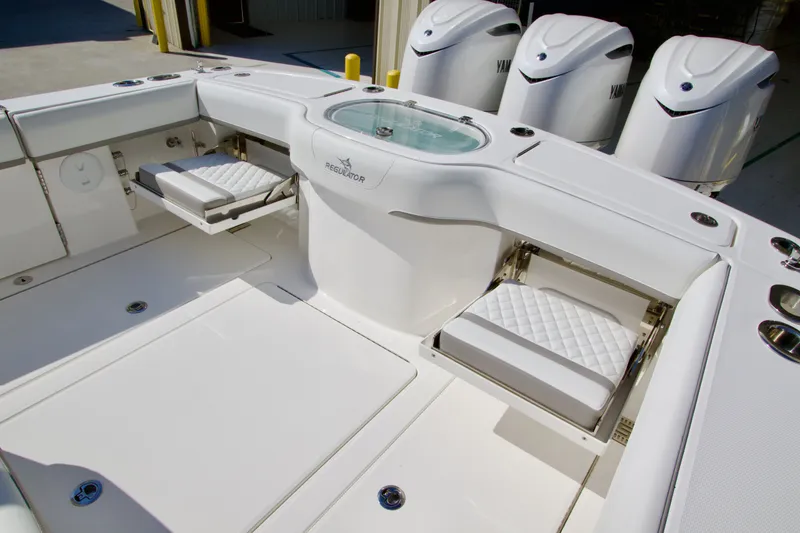 Slide: The Image of The image shows the cockpit of a Regulator 35 boat with white seats and engines. - 36
