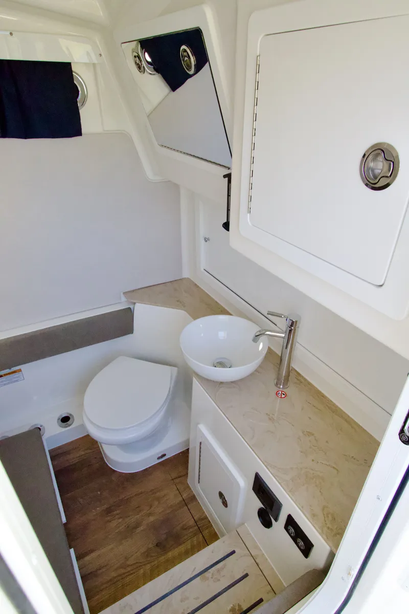Slide: The Image of Interior view of a boat with a toilet, sink, and wooden flooring. - 19