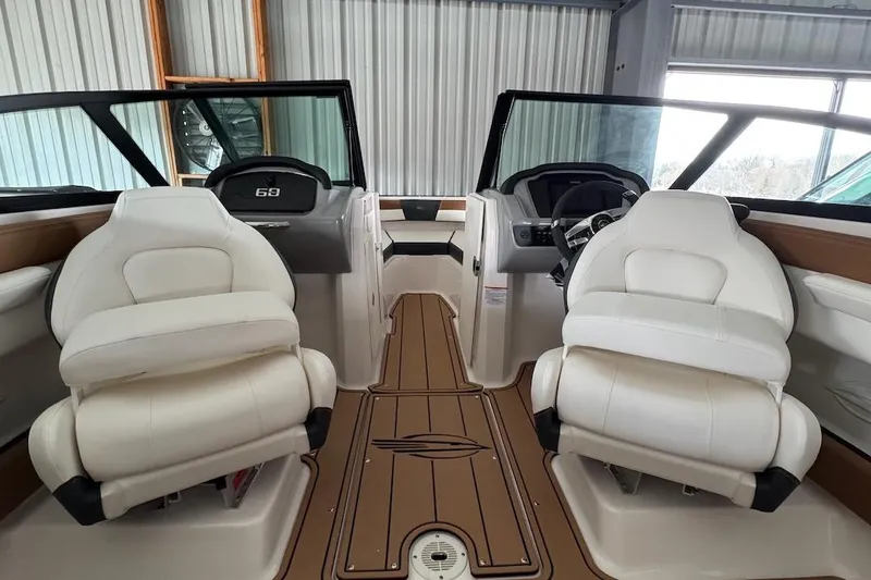 Slide: The Image of 2025 Chaparral 21 SSi OB boat interior with white seats and wood flooring. - 12