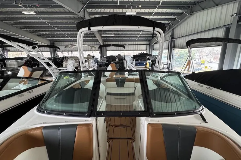 Slide: The Image of 2025 Chaparral 21 SSi OB boat interior in showroom, featuring sleek design and comfortable seating. - 15