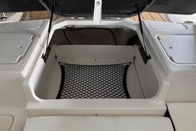 Slide: The Image of Open storage compartment in 2025 Chaparral 21 SSi OB boat with netting. - 19