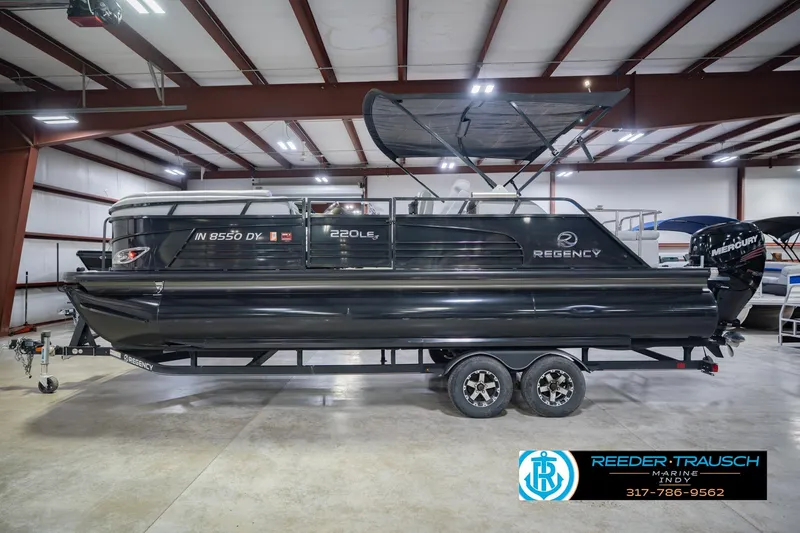 Slide: The Image of 2017 Bennington 220 LE3 pontoon boat in showroom, featuring sleek black design. - 11