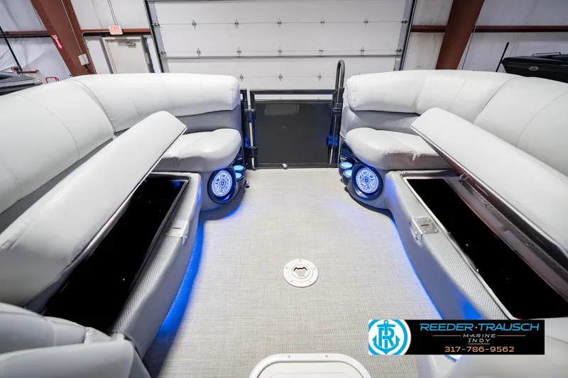 Slide: The Image of 2017 Bennington 220 LE3 pontoon boat interior with plush seating and blue LED lighting. - 22