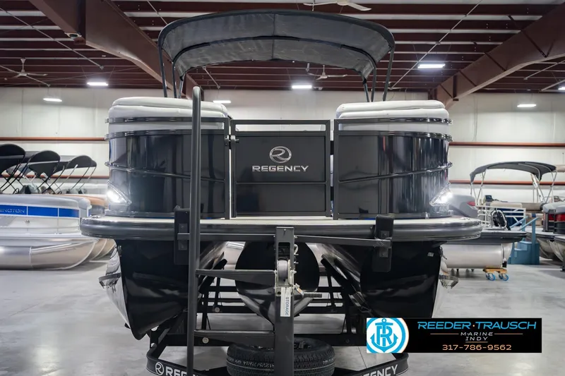 Slide: The Image of 2017 Bennington 220 LE3 pontoon boat in showroom, featuring sleek design and canopy. - 5