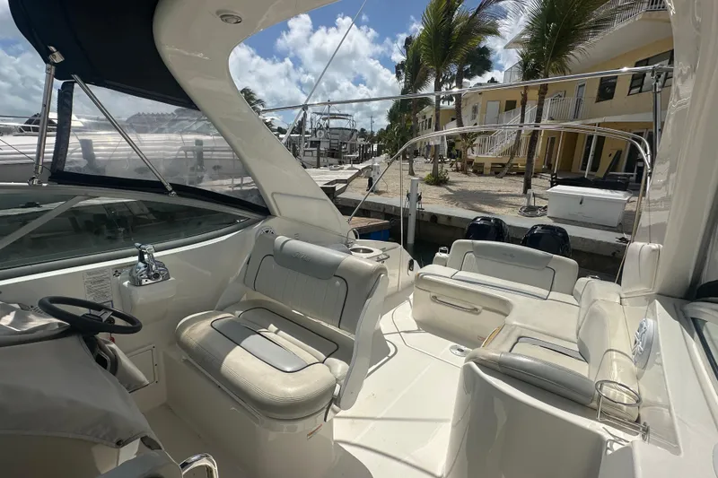 Slide: The Image of 2011 Sea Ray Sundancer 280 interior with seating, docked near palm trees and waterfront buildings. - 12