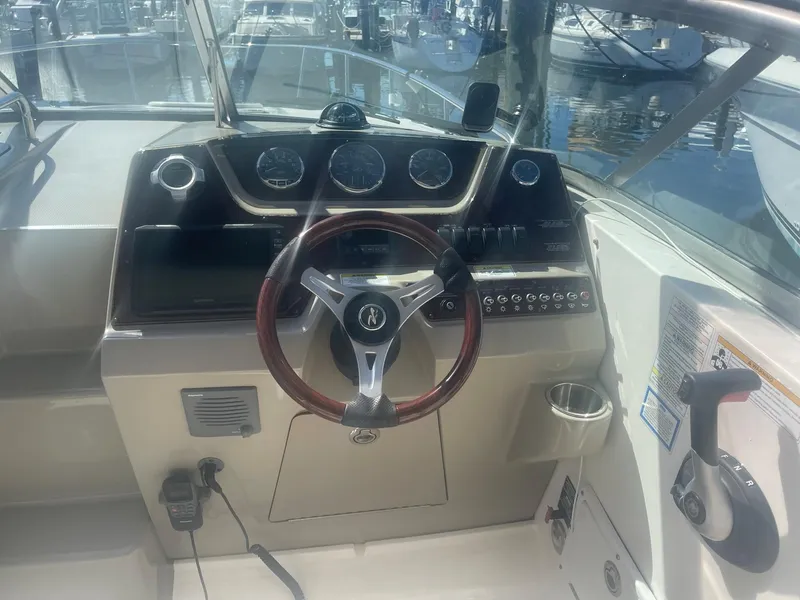 Slide: The Image of Sea Ray Sundancer 280 helm, 2011 model, featuring a wooden steering wheel. - 22