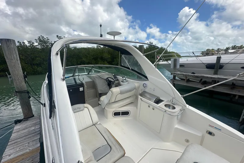Slide: The Image of 2011 Sea Ray Sundancer 280 boat interior at dock, featuring seating and helm. - 52