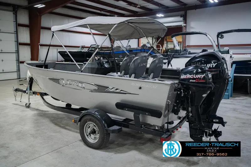 Slide: The Image of 2013 Lund 1650 Rebel XL Sport boat with Mercury engine in indoor showroom. - 10