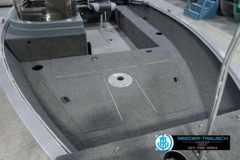 Slide: The Image of 2013 Lund 1650 Rebel XL Sport boat interior with carpeted deck and storage compartments. - 13
