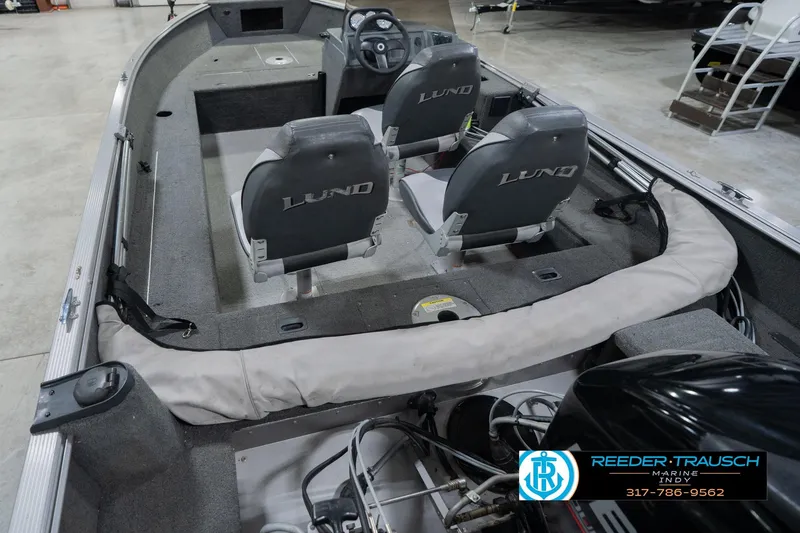 Slide: The Image of 2013 Lund 1650 Rebel XL Sport boat interior with seating and steering wheel. - 15