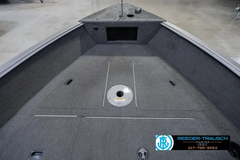 Slide: The Image of 2013 Lund 1650 Rebel XL Sport boat interior with carpeted deck and storage compartments. - 18