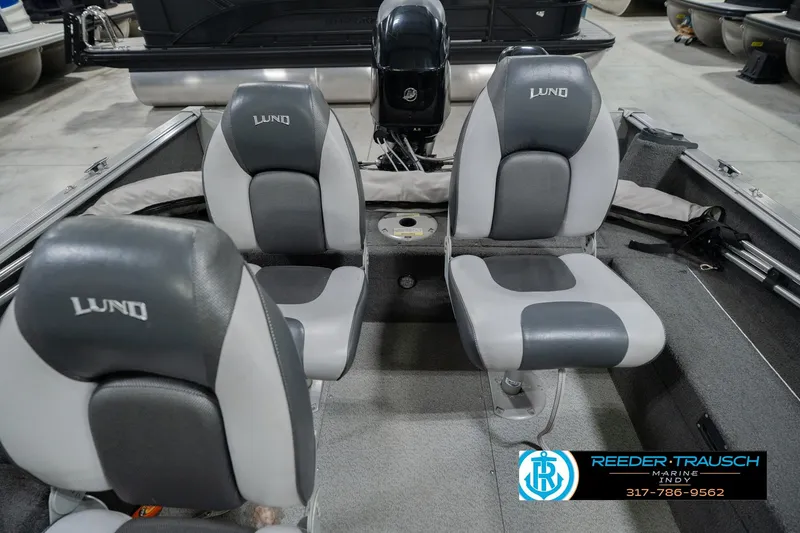 Slide: The Image of 2013 Lund 1650 Rebel XL Sport boat interior with gray seating and motor. - 21