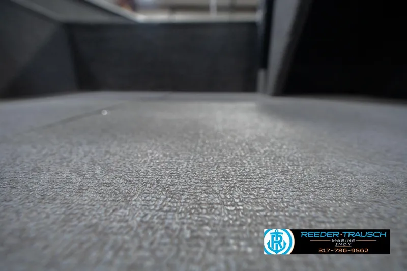Slide: The Image of Carpeted interior of a 2013 Lund 1650 Rebel XL Sport boat, featuring Reeder Trausch Marine logo. - 36