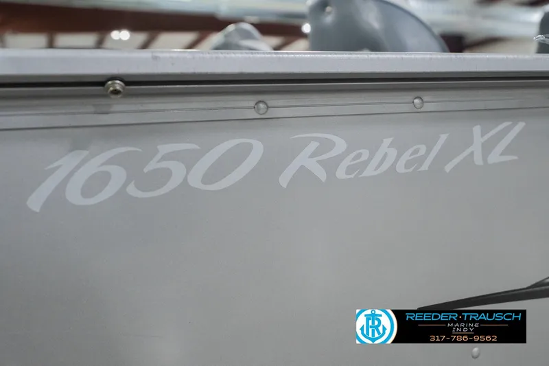 Slide: The Image of 2013 Lund 1650 Rebel XL Sport boat side view with logo and branding. - 46