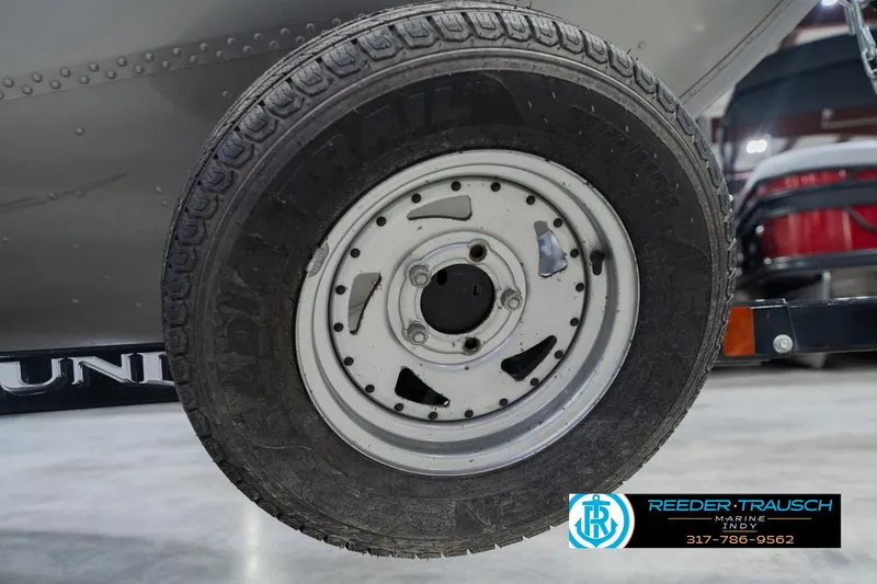 Slide: The Image of 2013 Lund 1650 Rebel XL Sport trailer wheel, close-up view in a showroom. - 50