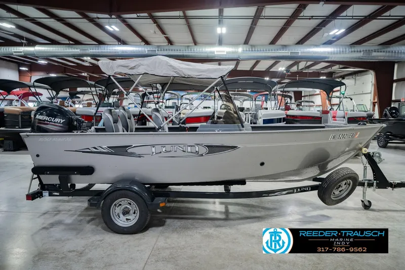 Slide: The Image of 2013 Lund 1650 Rebel XL Sport boat in showroom with Mercury engine. - 7
