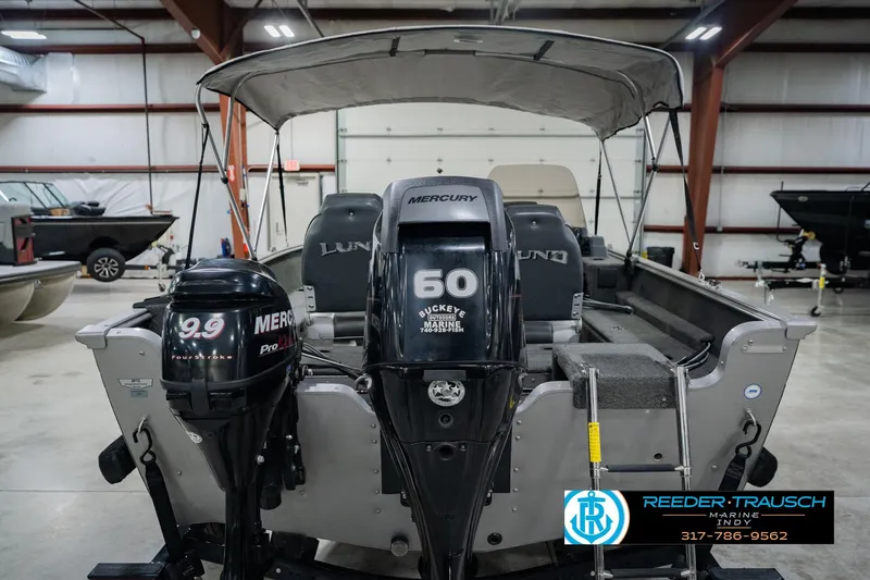 Slide: The Image of 2013 Lund 1650 Rebel XL Sport boat with dual Mercury outboard motors in a showroom. - 9
