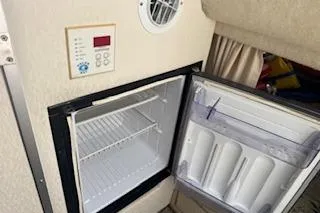 Slide: The Image of 2001 Maxum 2400 SCR boat interior with open mini fridge and control panel. - 10