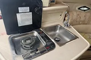 Slide: The Image of 2001 Maxum 2400 SCR boat kitchenette with stove and sink. - 11