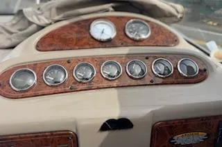 Slide: The Image of Dashboard of a 2001 Maxum 2400 SCR boat with multiple gauges and wood trim. - 2