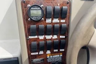 Slide: The Image of Control panel of a 2001 Maxum 2400 SCR boat with switches and a HawkEye display. - 3