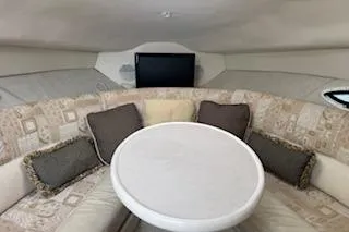 Slide: The Image of 2001 Maxum 2400 SCR cabin interior with round table and cushioned seating. - 6