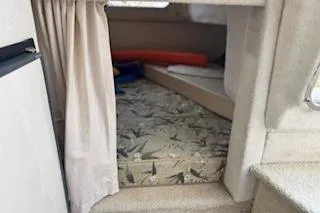 Slide: The Image of 2001 Maxum 2400 SCR cabin interior with bed and curtain. - 7