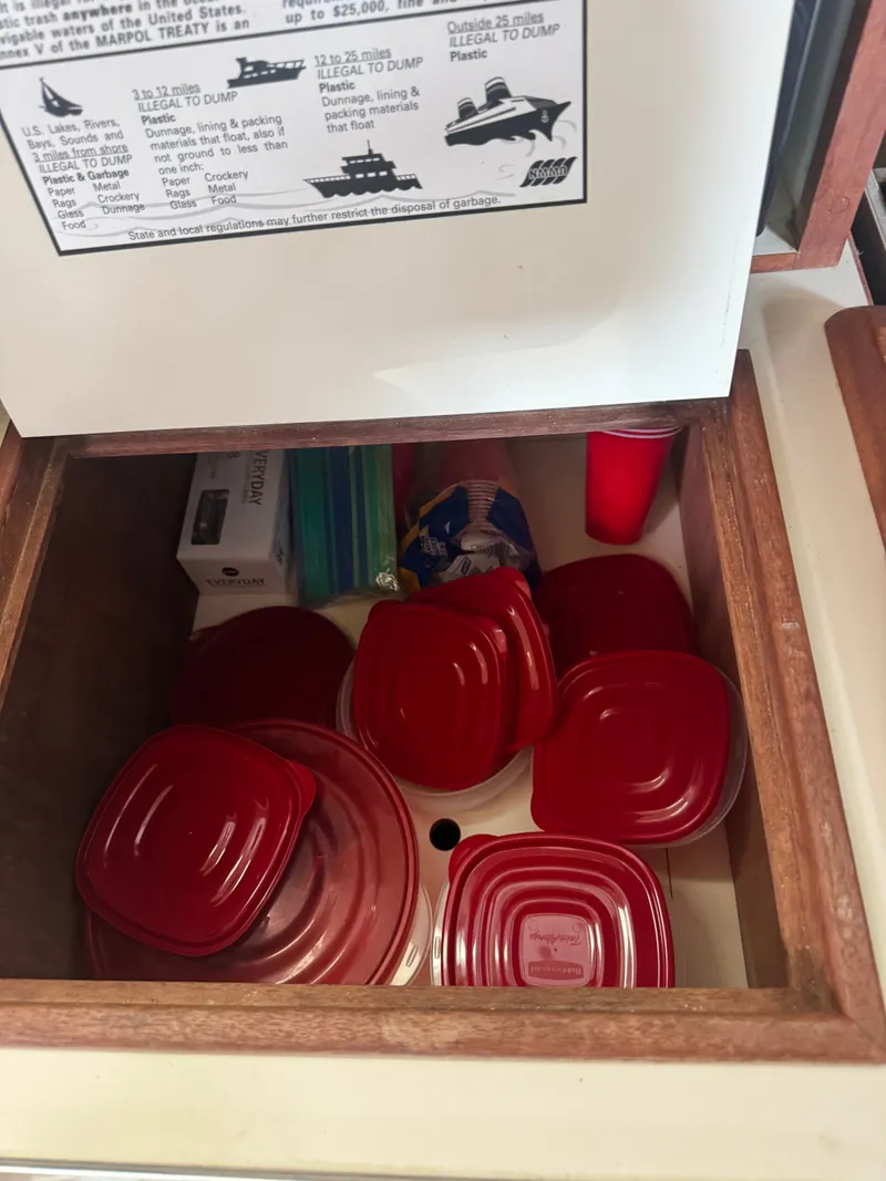 Slide: The Image of Red plastic dishware in a drawer on Island Packet 380, year 2001. - 30