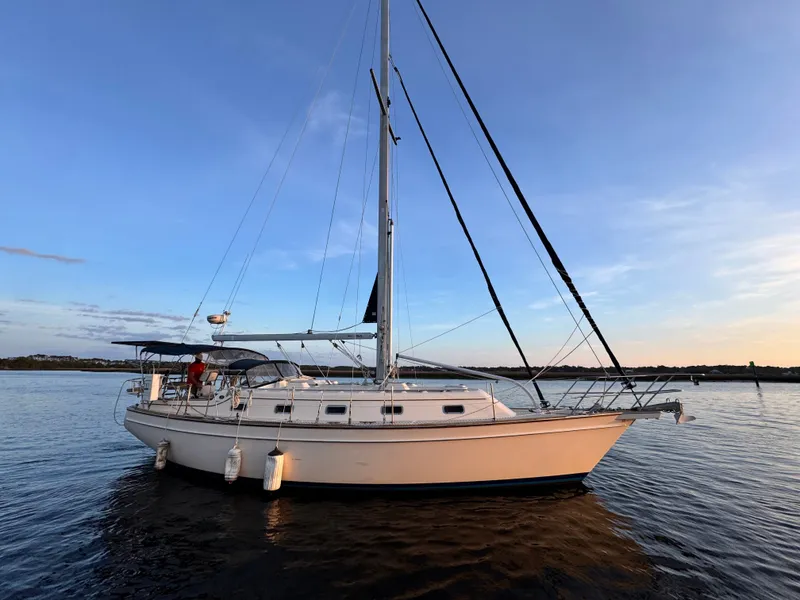 Slide: The Image of 2001 Island Packet 380 sailboat on calm water at sunset. - 6