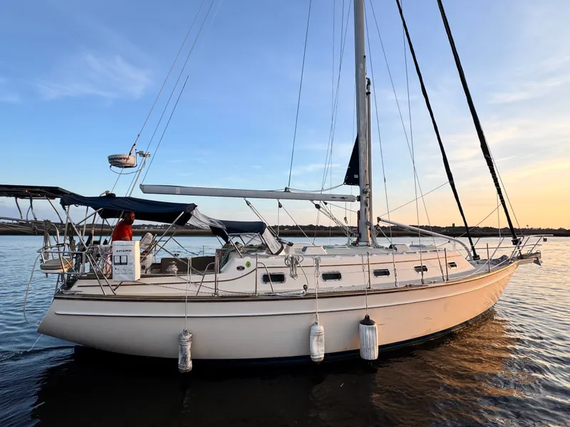 Slide: The Image of 2001 Island Packet 380 sailboat on calm water at sunset. - 7