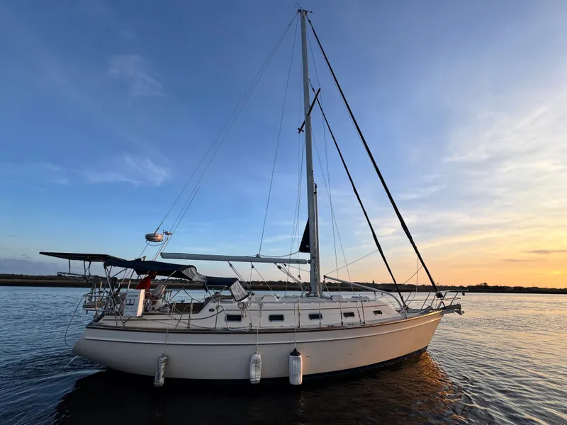 Slide: The Image of 2001 Island Packet 380 sailboat on water at sunset. - 8