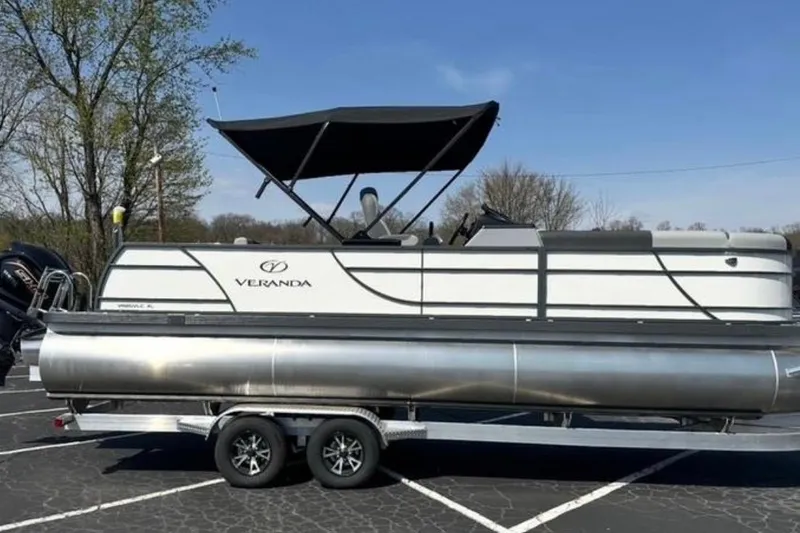 Slide: The Image of 2025 Veranda Relax VR25VLC pontoon boat on trailer, parked outdoors. - 21