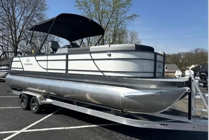 Slide: The Image of 2025 Veranda Relax VR25VLC pontoon boat on trailer, parked outdoors. - 22