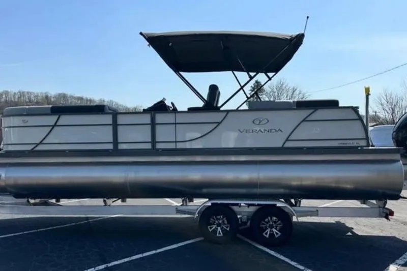 Slide: The Image of 2025 Veranda Relax VR25VLC pontoon boat on trailer, parked outdoors. - 3