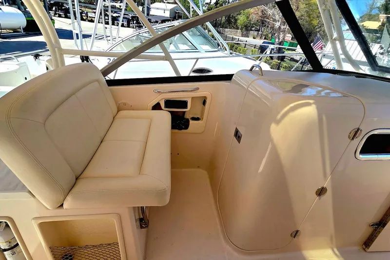 Slide: The Image of 2015 Grady-White Freedom 307 boat interior with beige seating and helm area. - 11