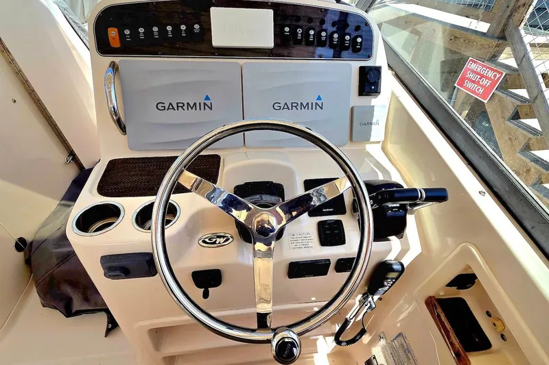 Slide: The Image of 2015 Grady-White Freedom 307 boat helm with Garmin navigation system and steering wheel. - 8