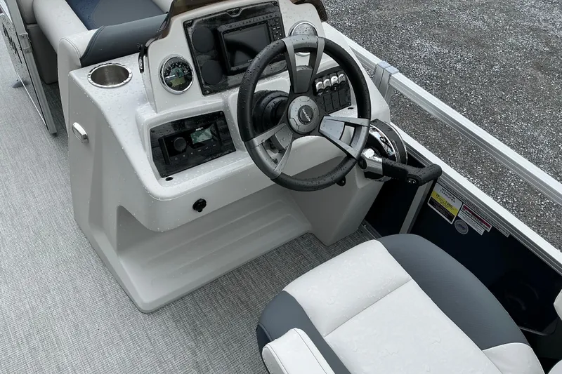 Slide: The Image of Interior of 2026 Avalon Venture Quad Lounge boat, featuring steering console and seating. - 7