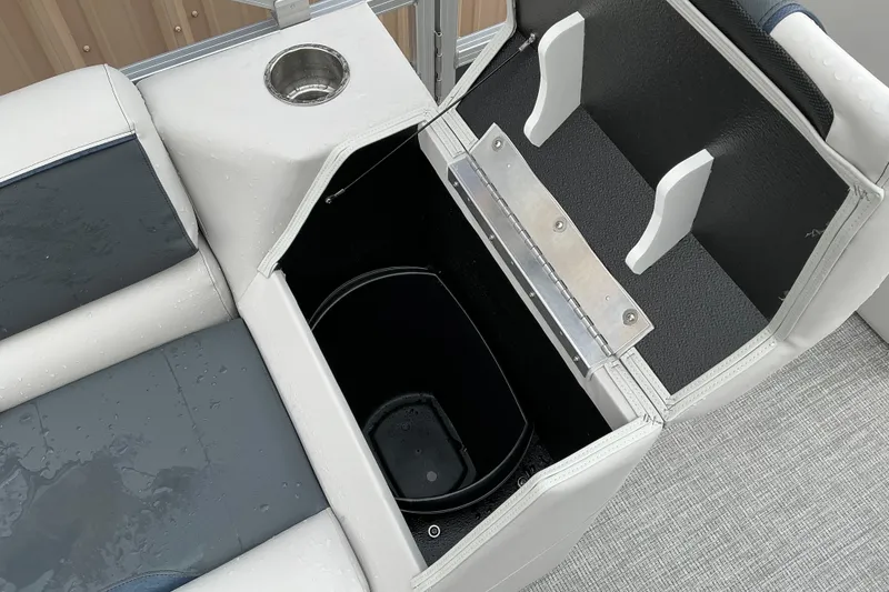 Slide: The Image of Interior storage compartment of 2026 Avalon Venture Quad Lounge boat, featuring cup holder and seating. - 8